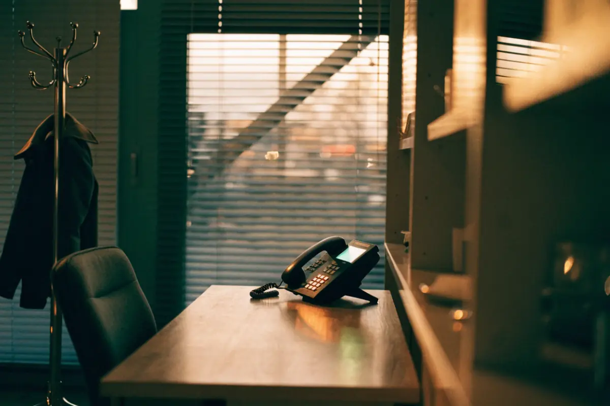 A ringing office phone on an empty front desk after hours