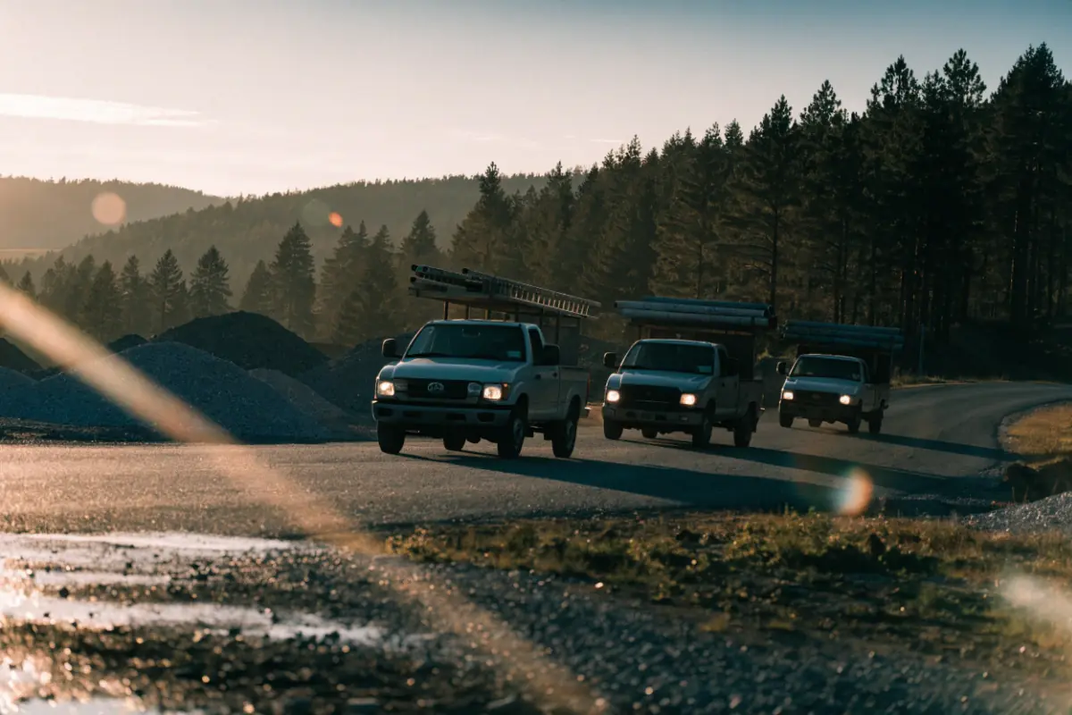 A row of local service trucks heading out for the day at sunrise