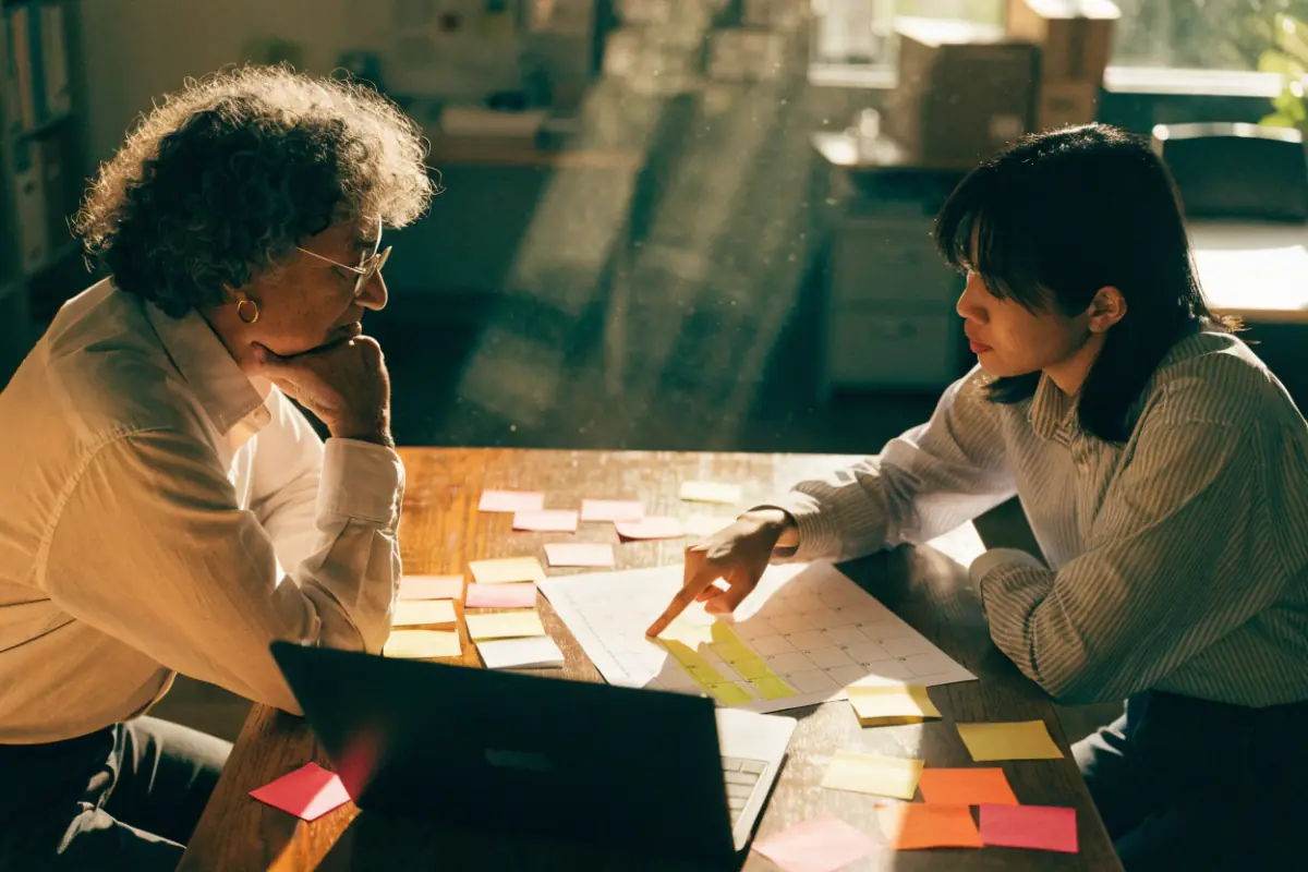 A business owner and planner mapping out a campaign at a wooden table