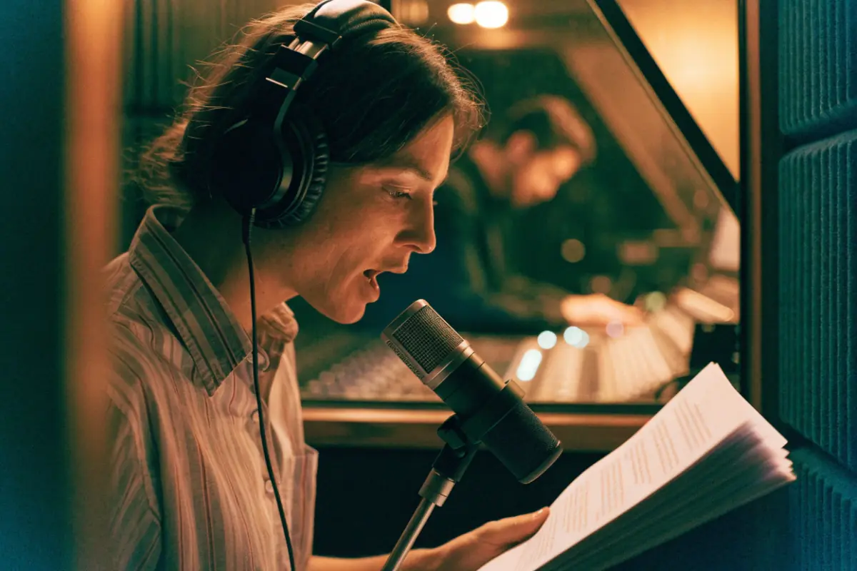 A producer recording a radio spot in a small studio