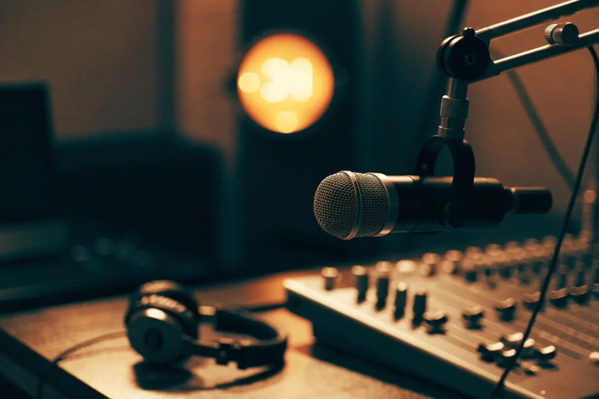 A radio station studio microphone glowing in a dim booth