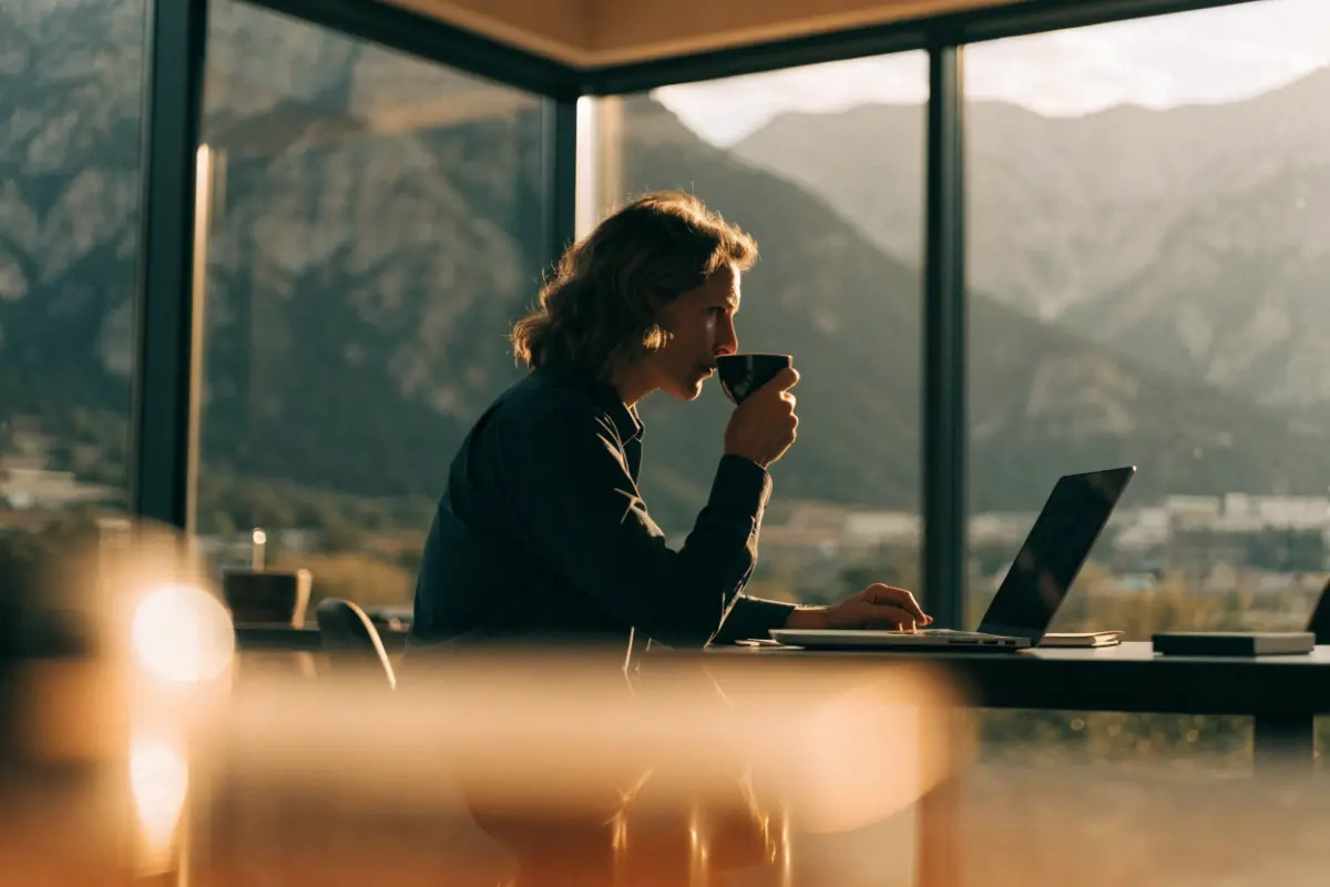 A professional reviewing a business offer on a laptop in a modern office