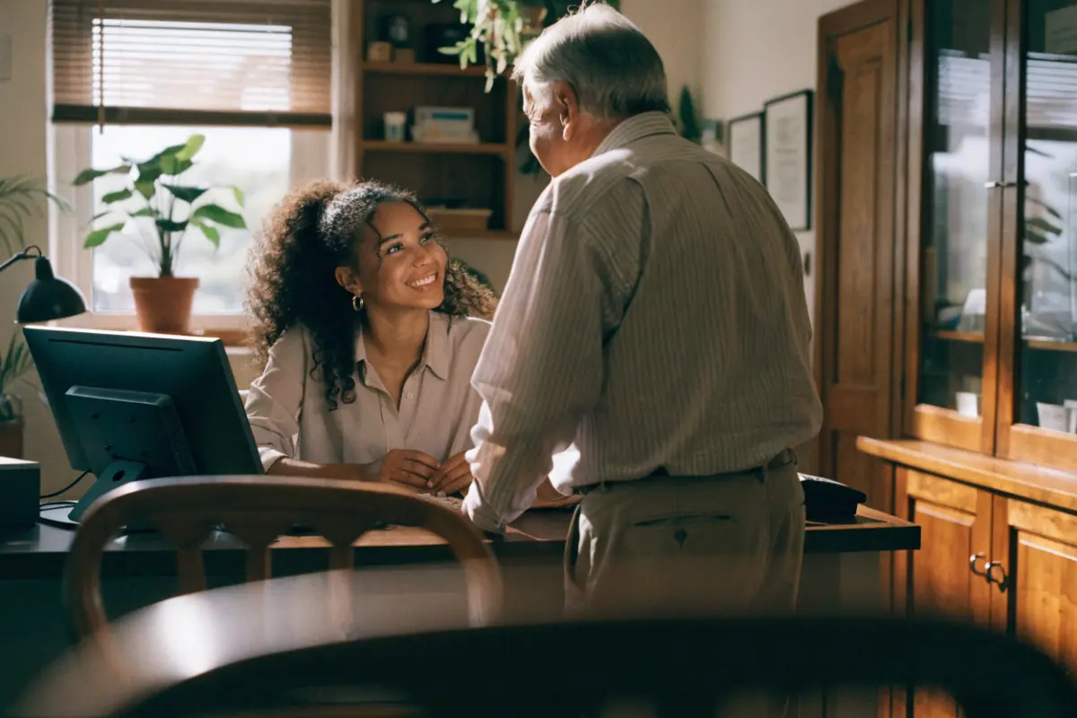 A friendly clinic front desk greeting a patient
