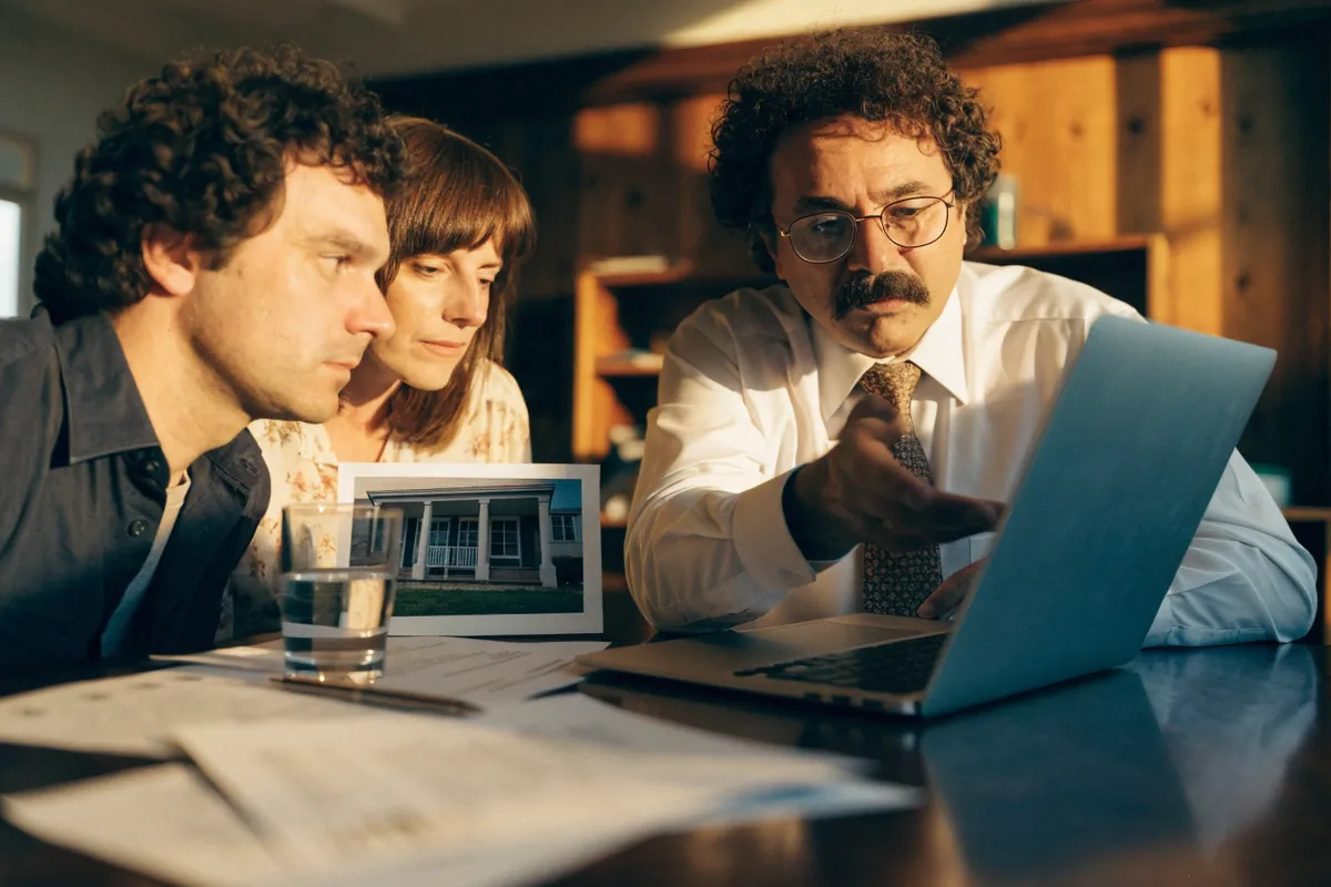 A loan officer walking a couple through a home loan pre-approval on a laptop