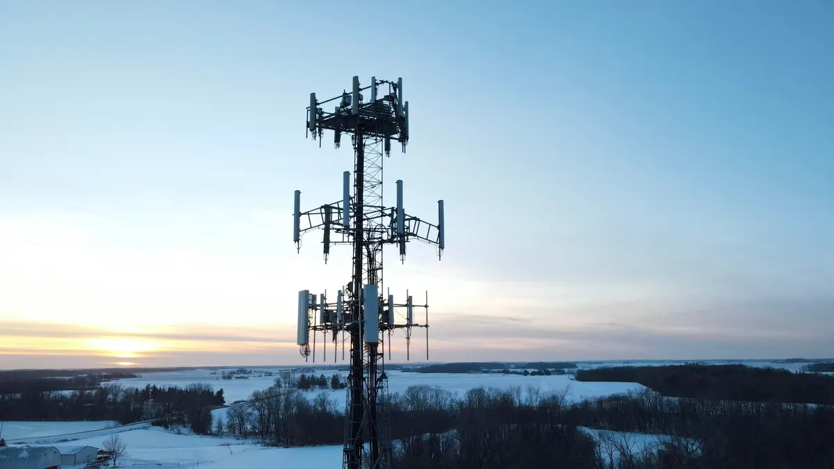 Broadcast radio tower silhouetted against a winter sunset